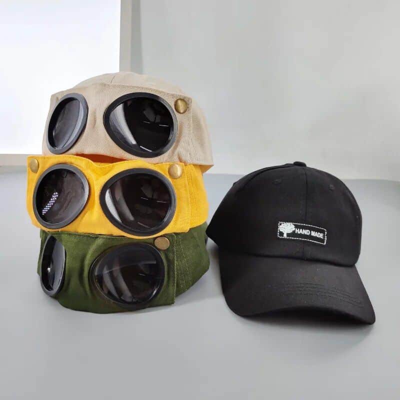 Optical goggles caps with lens storage and a "Hand Made" baseball cap, stylish accessories ideal for opticians, eyewear enthusiasts, and fashion-forward individuals.