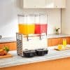 Juice dispenser with two chambers, one yellow and one red, perfect for serving fresh fruit juices in commercial and hospitality settings.