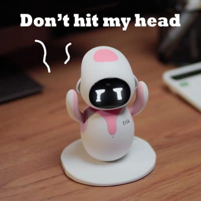 Mini robot figurine with expressive face, emphasizing warning about head injury, ideal for tech or toy-related content.