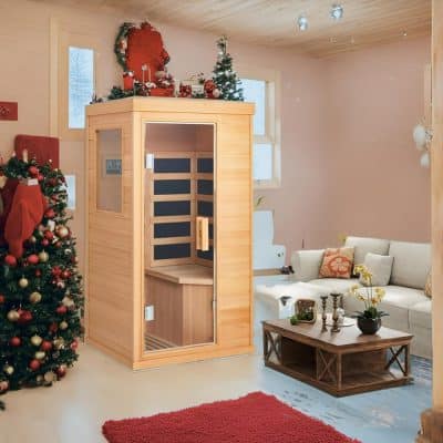 A wooden sauna room inside a festive living room, decorated for Christmas with a Christmas tree, ornaments, and holiday decor, perfect for a relaxing spa experience during the holidays.