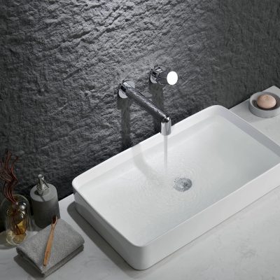 Stylish white rectangular bathroom sink with sleek chrome faucet and minimalist decor, ideal for a contemporary wellness or skincare setting.