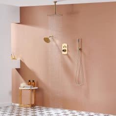 Luxurious bathroom shower setup featuring elegant gold fixtures, a rainfall showerhead, and warm tones creating a relaxing space.