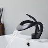 Sleek black water faucet mounted above a white sink, providing a stylish and functional feature for modern bathrooms or salons.