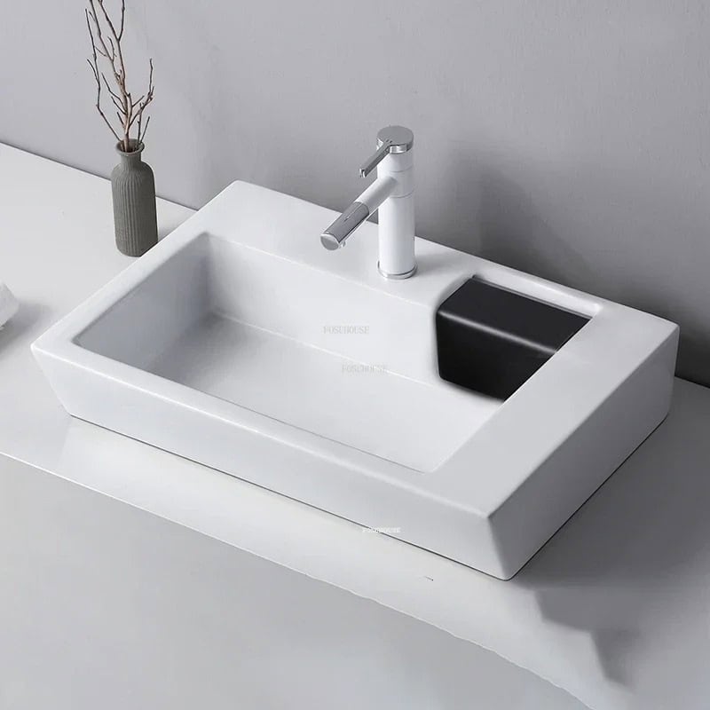 Elegant white bathroom sink with chrome faucet, durable design, perfect for home or clinic washbasins. Includes integrated black soap or storage holder, stylish and functional.