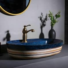 Luxury bathroom vanity with stylish blue and striped ceramic basin, brass faucet, and minimalist decor for premium interior design.