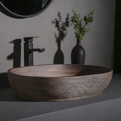 Elegant wooden bathroom sink with black faucet, complemented by a black vase with green foliage, showcasing contemporary bathroom design at Monalisa Store.