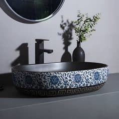 Elegant ceramic bathroom sink featuring a blue floral design and Greek key border, perfect for enhancing bathroom aesthetics and functionality.