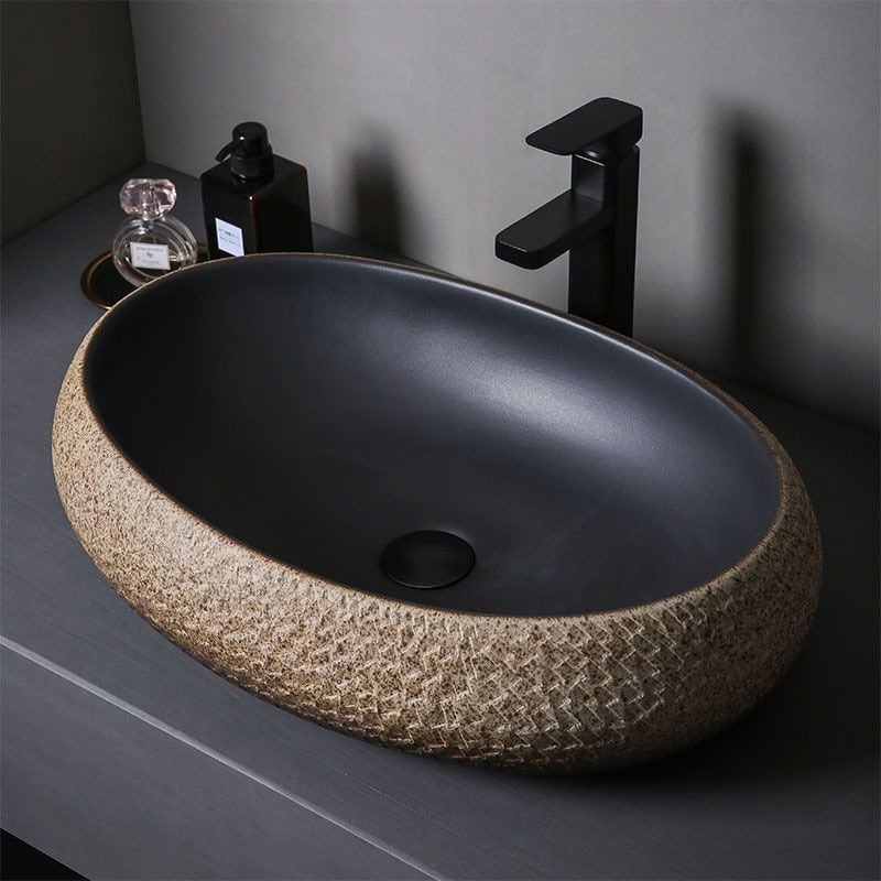 Elegant stone sink with black faucet for bathroom decor.