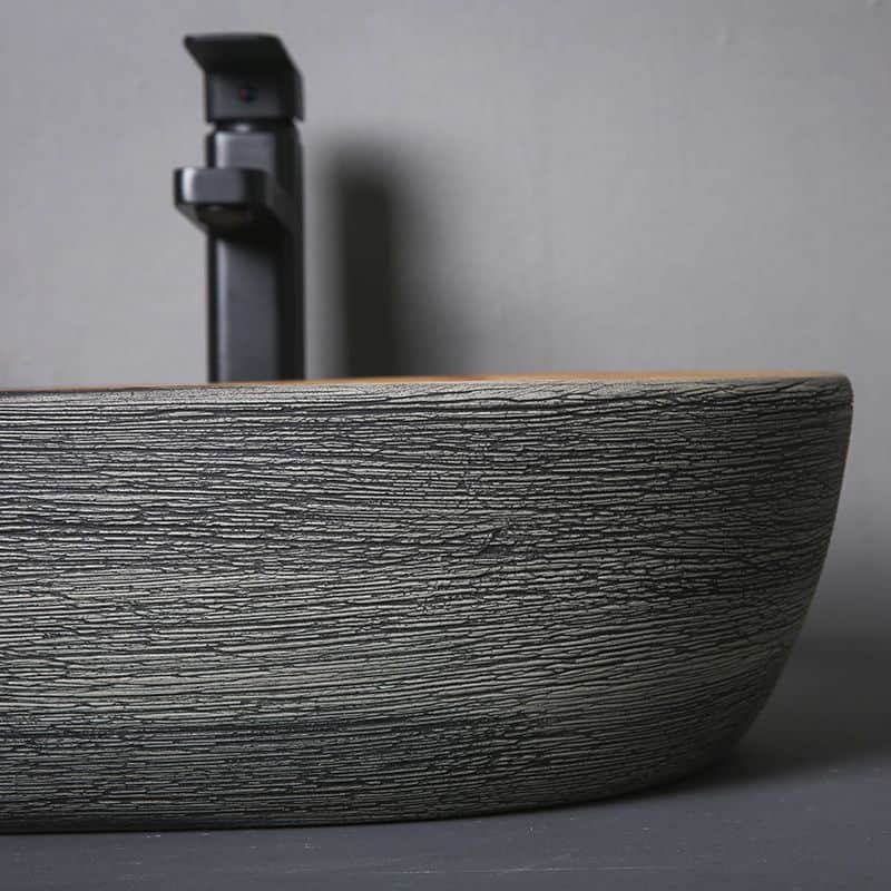 High-resolution image of a modern bathroom sink featuring a textured stone basin and a black faucet, showcasing contemporary design elements perfect for opt clinic decor or upscale restroom environments. An elegant, minimalist aesthetic that combines durability and style for sophisticated bathroom or optical space setups.