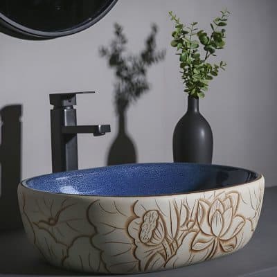 Bright, sleek bathroom sink with decorative floral design, black faucet, and elegant décor, perfect for optometry or medical clinic interiors.