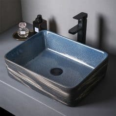 Luxurious blue ceramic vessel sink with a sleek black faucet, perfect for upscale bathrooms, combining modern design with durability for elegant washbasin setups.