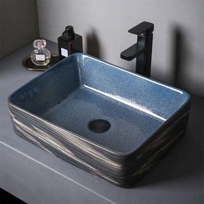 Luxurious blue ceramic vessel sink with a sleek black faucet, perfect for upscale bathrooms, combining modern design with durability for elegant washbasin setups.