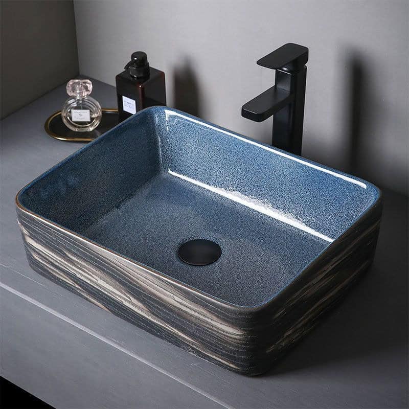 Luxurious blue ceramic vessel sink with a sleek black faucet, perfect for upscale bathrooms, combining modern design with durability for elegant washbasin setups.