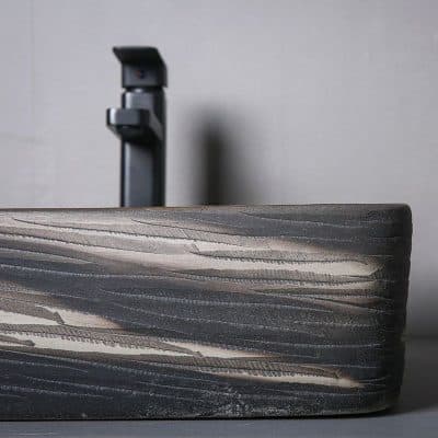 Elegant modern black faucet installed in a sleek concrete countertop, ideal for medical or professional settings, highlighting contemporary design and durability.