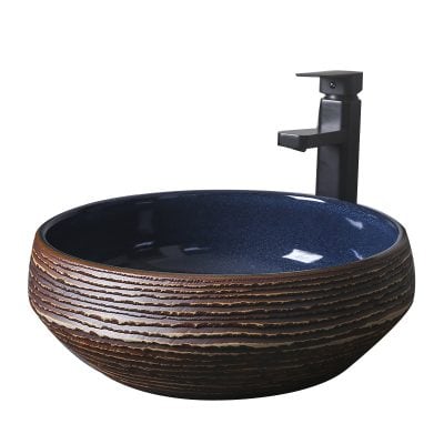 A sleek black ceramic washbasin featuring textured, earthy exterior design with a smooth, glossy navy blue interior, paired with a modern black faucet for stylish bathroom decor.