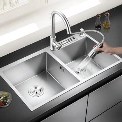 Modern stainless steel kitchen sink with high-arc faucet, dual basins, and removable spray nozzle for easy cleaning and versatile use.