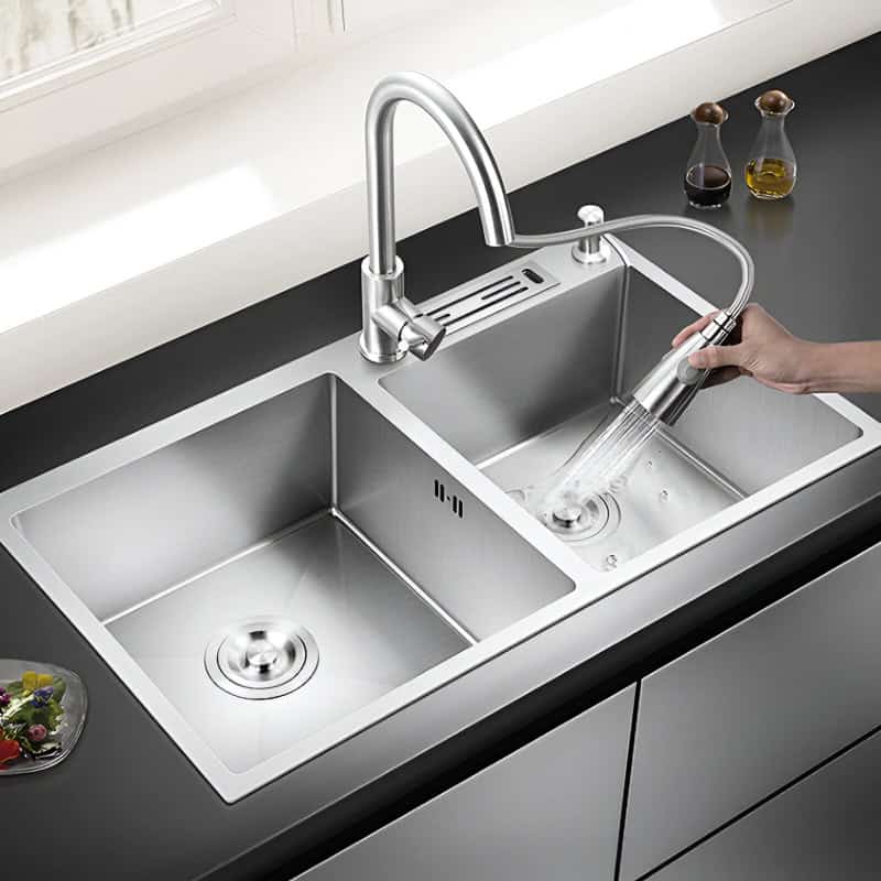 Modern stainless steel kitchen sink with high-arc faucet, dual basins, and removable spray nozzle for easy cleaning and versatile use.
