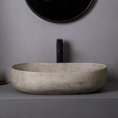 Elegant stone bathroom sink with sleek black faucet, minimalist design, perfect for contemporary bathrooms.