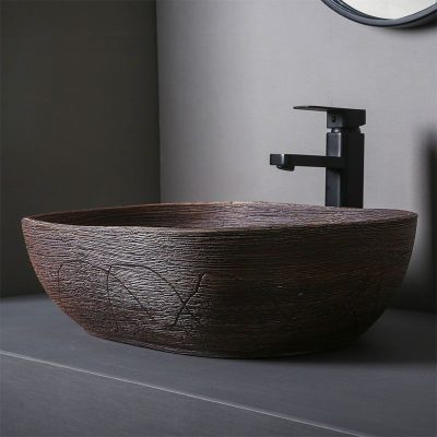 Elegant vessel sink with textured wood-like finish and sleek black faucet in contemporary bathroom setting, perfect for modern home or spa renovation.
