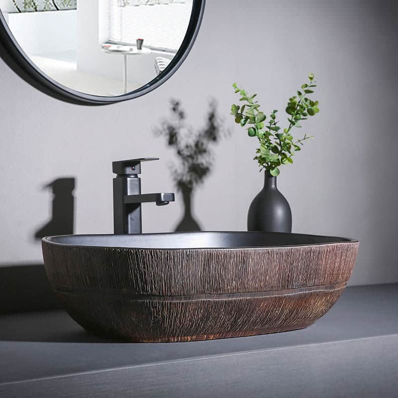 Elegant ceramic basin with black faucet and greenery, perfect for modern optometry clinic decor showcasing design and functionality.
