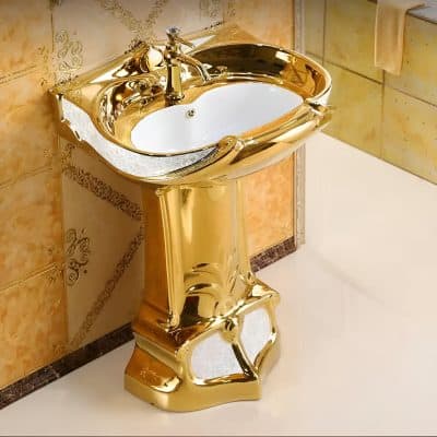 Elegant gold-tone bathroom sink with intricate details and a matching faucet, perfect for upscale bathroom interiors.