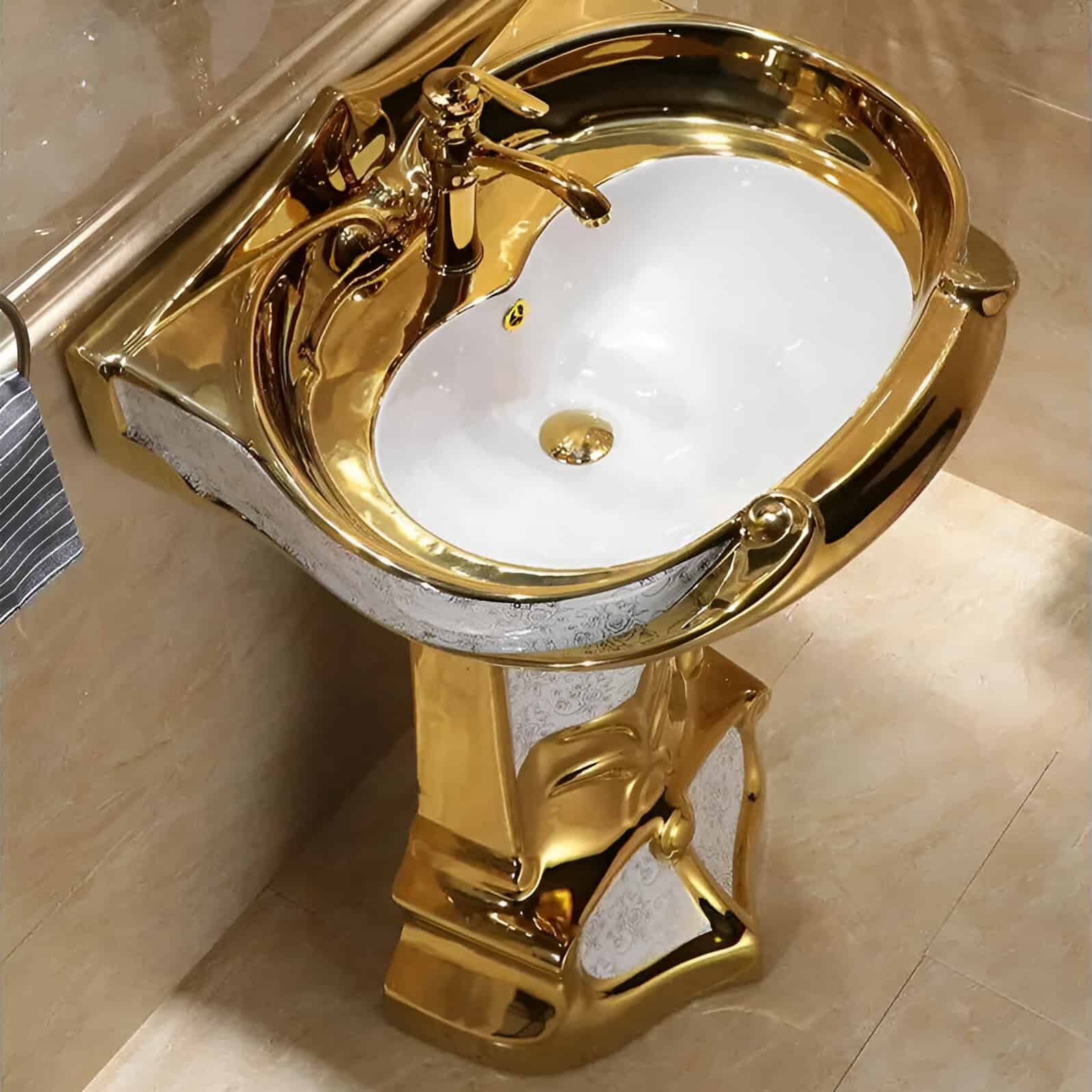 A sophisticated gold-colored sink with a sleek, shiny finish and ornate carved details, perfect for upscale bathrooms or salons focused on luxury and aesthetics.