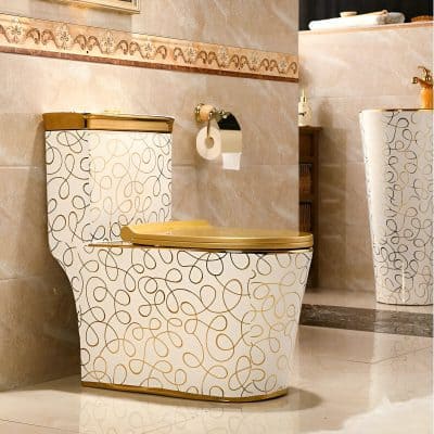 Luxurious bathroom toilet with gold accents, decorative swirl pattern, and elegant setting, ideal for upscale optometry and eyewear stores.