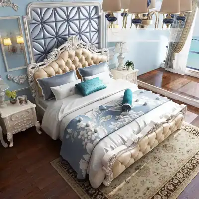 Elegant bedroom with ornate cream tufted headboard, classic white nightstands, and sophisticated blue accents for a timeless, luxurious feel. Perfect for upscale home furniture and bedroom design.