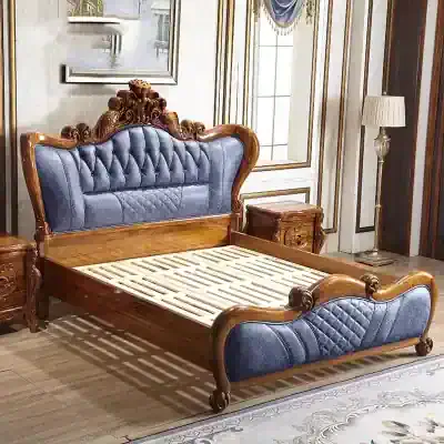 Luxurious vintage bed with upholstered headboard and footboard, featuring intricate wood carvings and plush blue fabric, ideal for luxury bedroom decor.