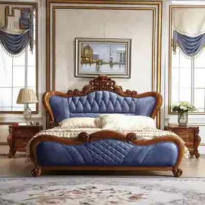 Luxury bedroom furniture featuring a blue velvet tufted bed with carved wooden details, side tables with lamps, and elegant curtains for a refined look.