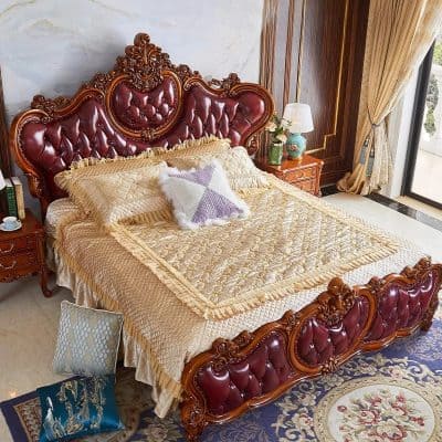 Elegant, ornate wooden bed frame with red leather upholstery, perfect for upscale bedroom decor and comfort.