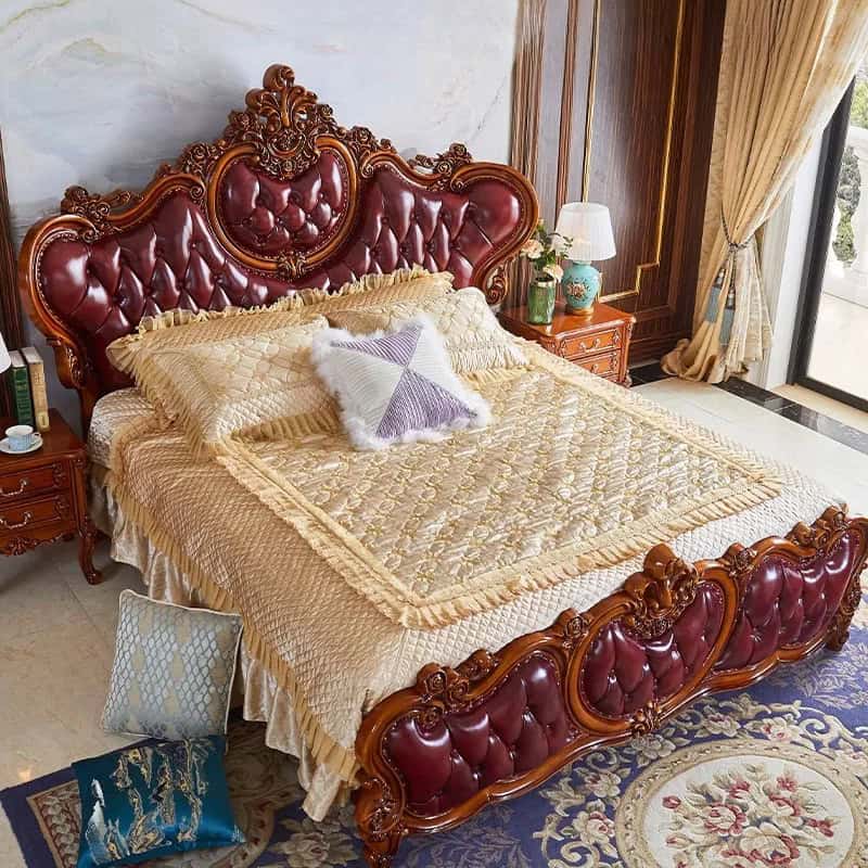 Elegant, ornate wooden bed frame with red leather upholstery, perfect for upscale bedroom decor and comfort.