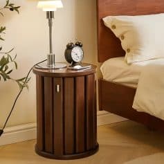 High-quality wooden bedroom nightstand with a silver lamp and vintage alarm clock, perfect for a cozy and stylish sleep space.