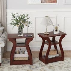 Stylish wooden side tables with flowers, lamp, and framed photo in elegant living room decor.