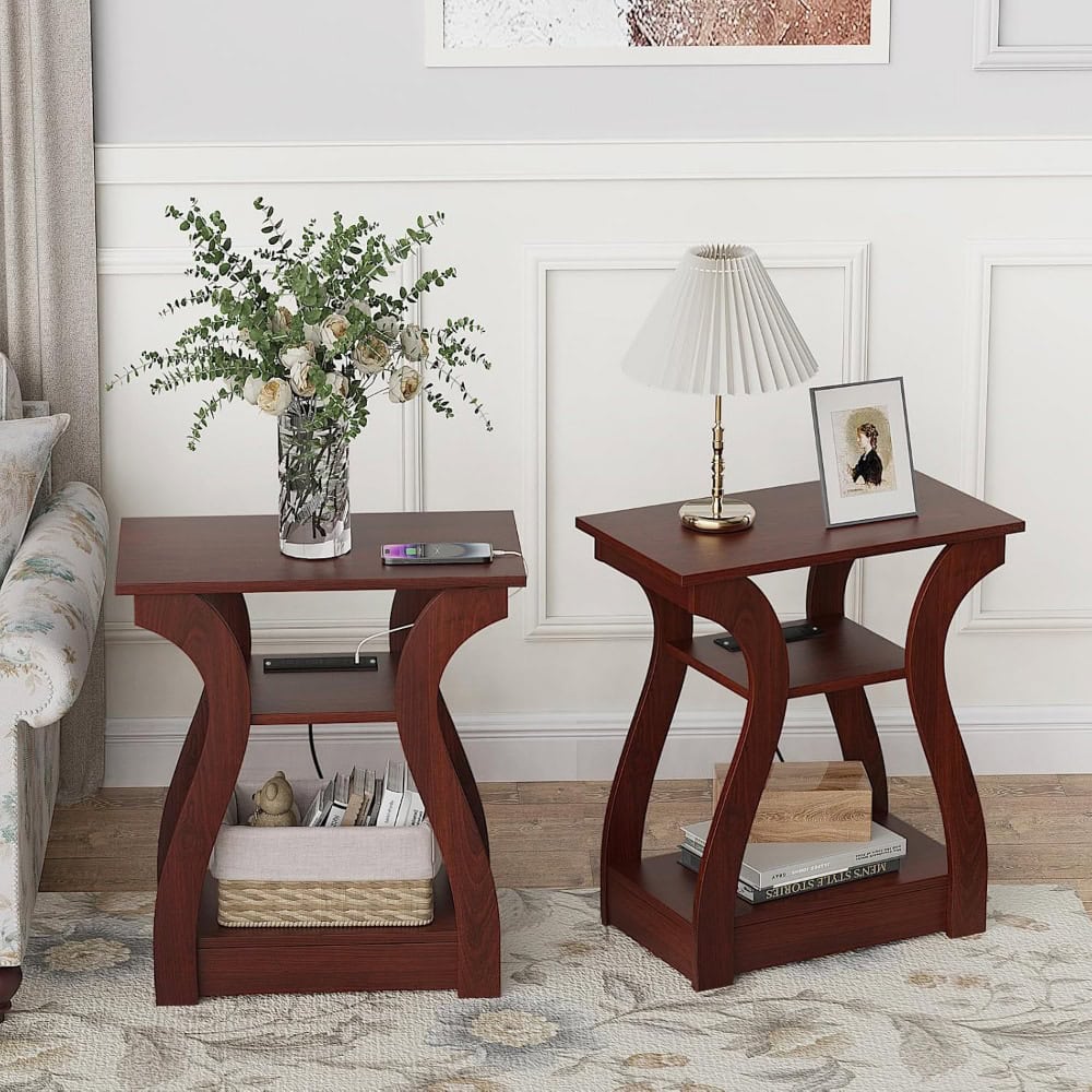 Stylish wooden side tables with flowers, lamp, and framed photo in elegant living room decor.