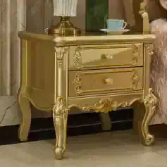 Luxurious gold bedside table with ornate detailing and two drawers, perfect for bedroom decor and storage. Adds a touch of elegance and sophistication to your bedroom furniture.