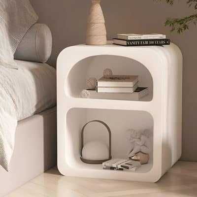 Versatile and elegant white nightstand featuring rounded edges and open shelving, perfect for bedroom decor, displaying books and ornaments for a contemporary look.