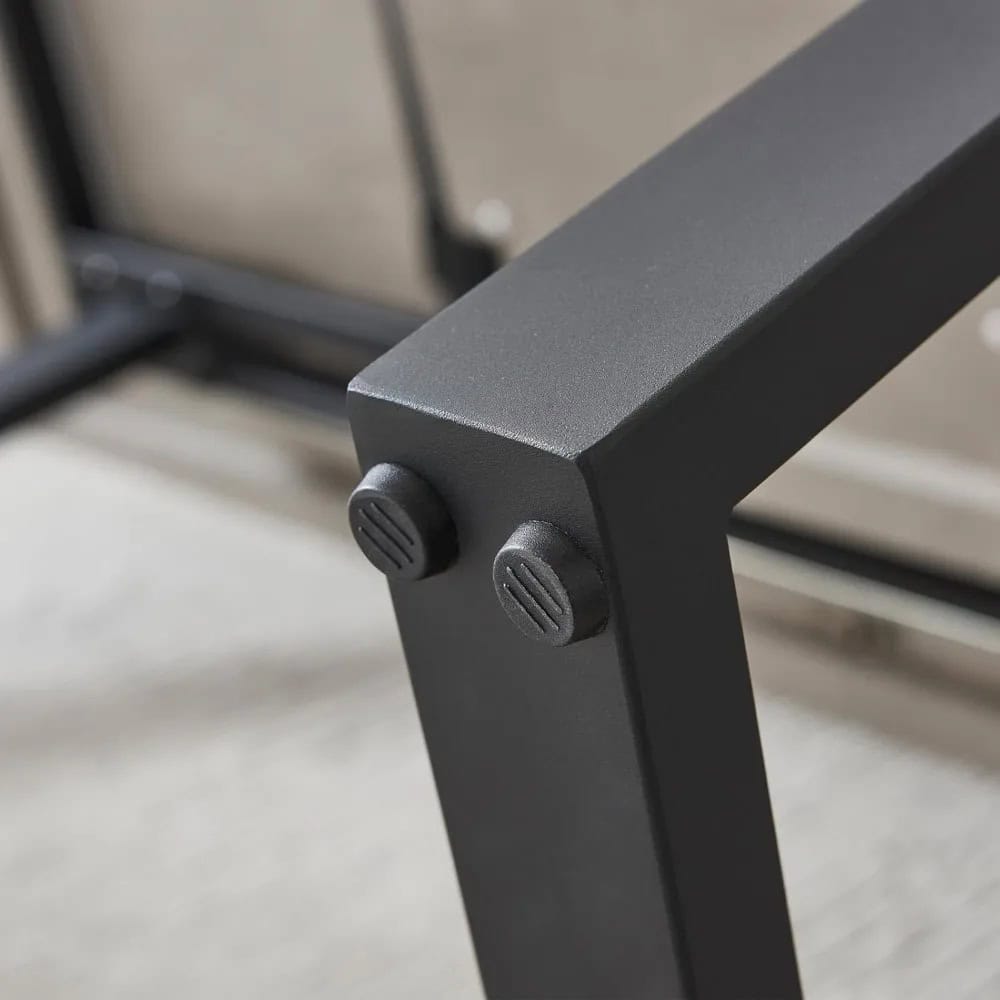 Close-up of a black metal medical examination table support with adjustable knobs for stability and comfort in healthcare settings.