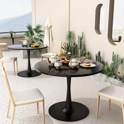 Chic, modern tea party setup with black tables, floral china, and lush greenery at Monalisa Store's elegant medical and wellness lounge in a serene, stylish environment.
