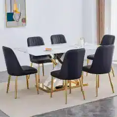 Elegant dining room set featuring black upholstered chairs with tufted backs, a white marble table with gold geometric legs, perfect for contemporary interiors.