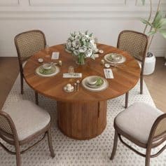 Stylish round dining table with beautiful chairs, floral centerpiece, and fine tableware, ideal for elegant home or restaurant dining settings.