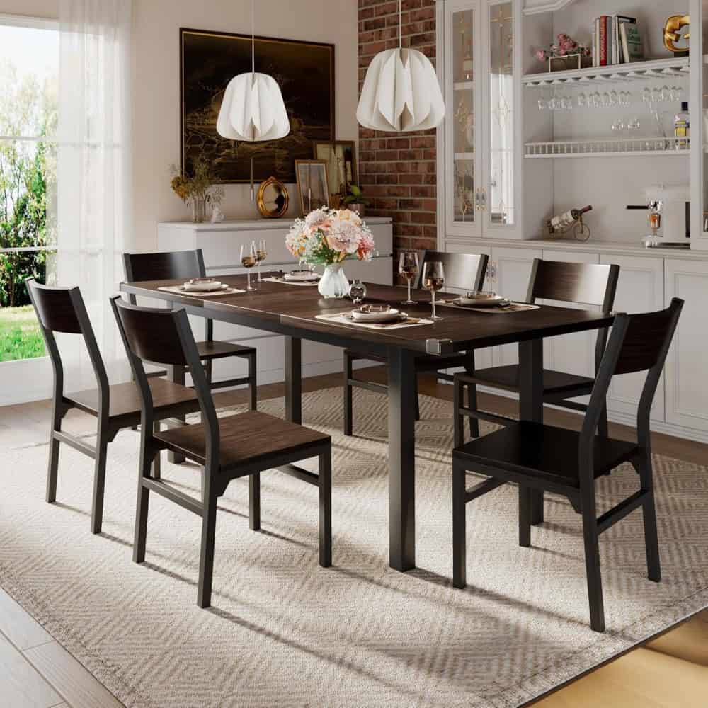 Elegant dining room with black wood table, six matching chairs, white china, wine glasses, floral centerpiece, and contemporary decor.