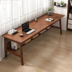 A sleek wooden desk used in an optometry clinic with a laptop, eye care tools, books, and decorative plant, creating a professional environment for eye health and optical services at Monalisa Store.