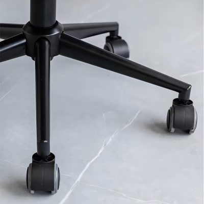 Office chair wheel base on a smooth, light gray surface, emphasizing mobility and ergonomic design for workplace comfort.