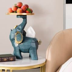 Elegant tissue holder in the shape of a peach-colored elephant with a tray of peaches on its back.