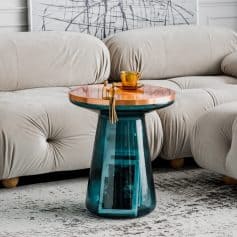 Stylish glass and wood coffee table with decorative figurines and a mug, perfect for contemporary home decor and adding elegance to your living space.