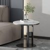Sleek side table in a contemporary living room with a white marble top and black metal base, decorated with a glass vase containing greenery and books, perfect for stylish home decor.