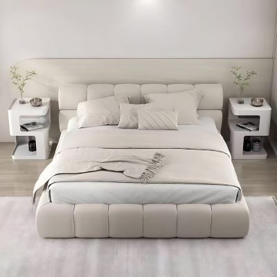 Elegant white bed with soft pillows, stylish side tables with decorative accents, perfect for a modern bedroom design.