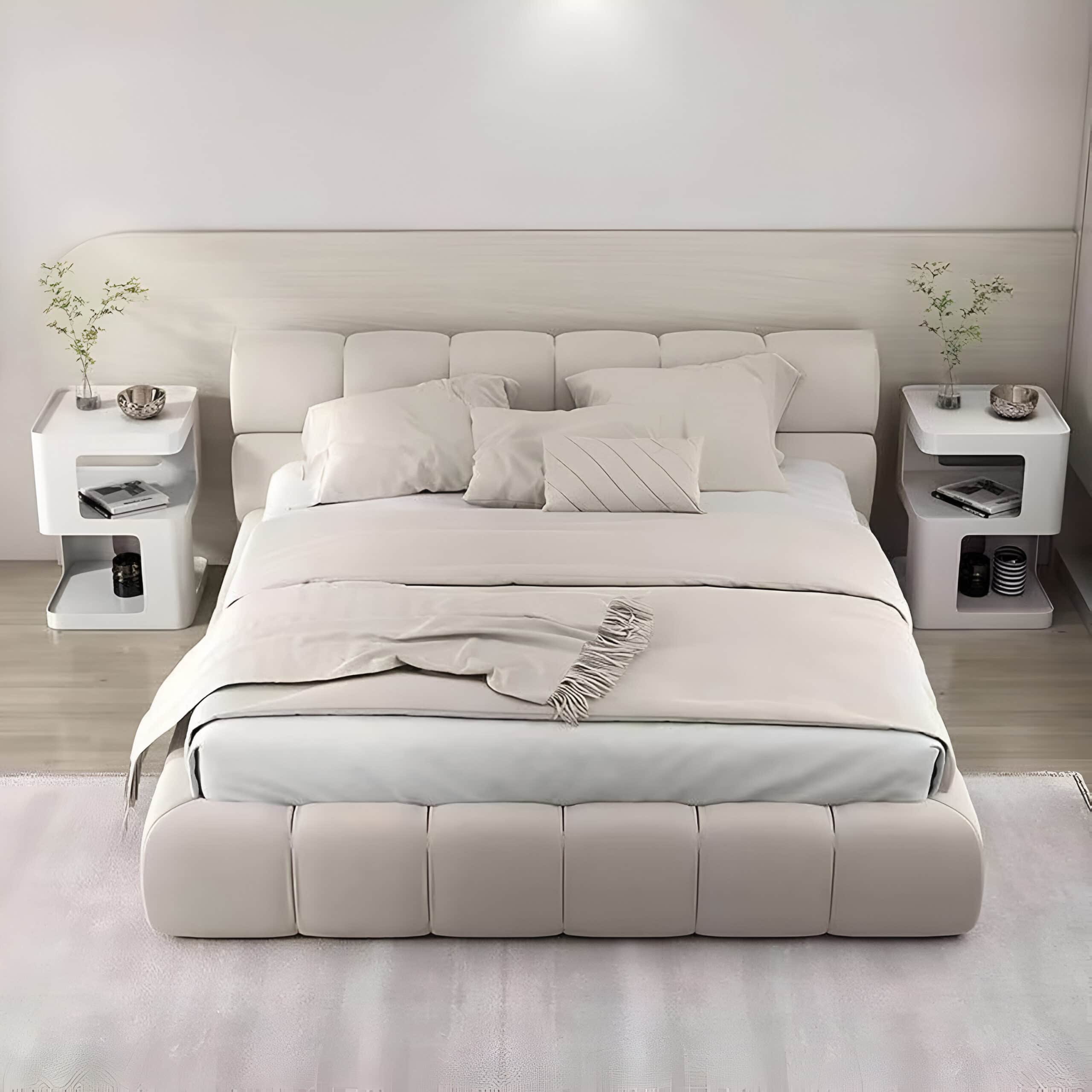 Elegant white bed with soft pillows, stylish side tables with decorative accents, perfect for a modern bedroom design.
