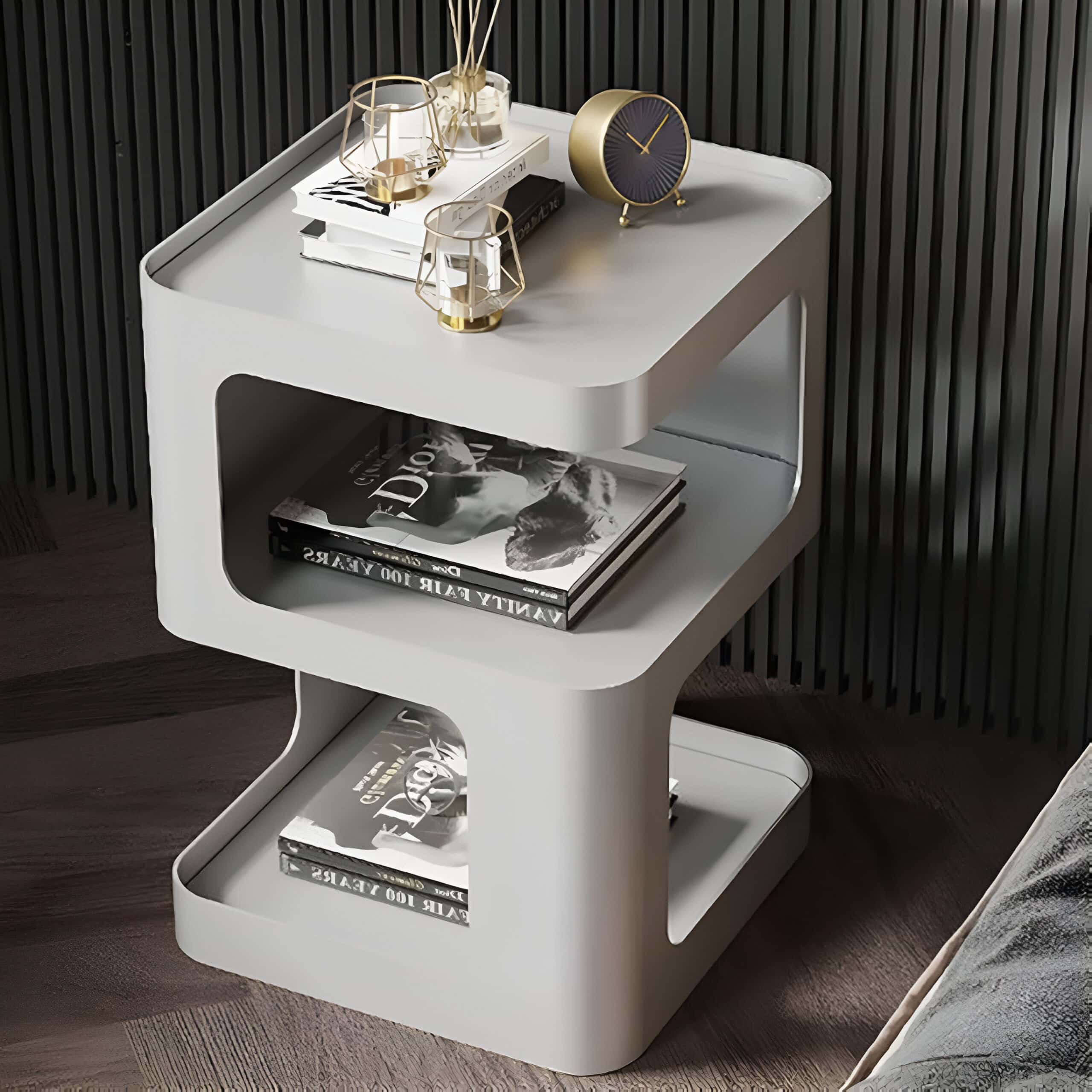 Stylish white nightstand featuring open shelves for magazines, modern decorative glass accessories, and a sleek black and gold clock accentuate an elegant optometry space.